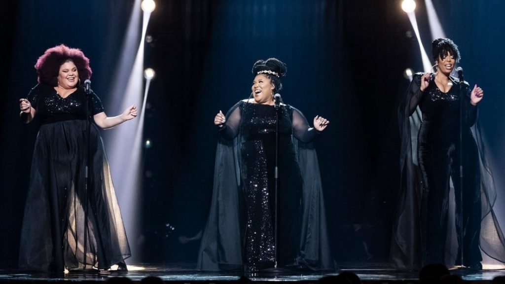 The Mamas on the Melodifestivalen 2020 stage singing in harmony. They are wearing black.