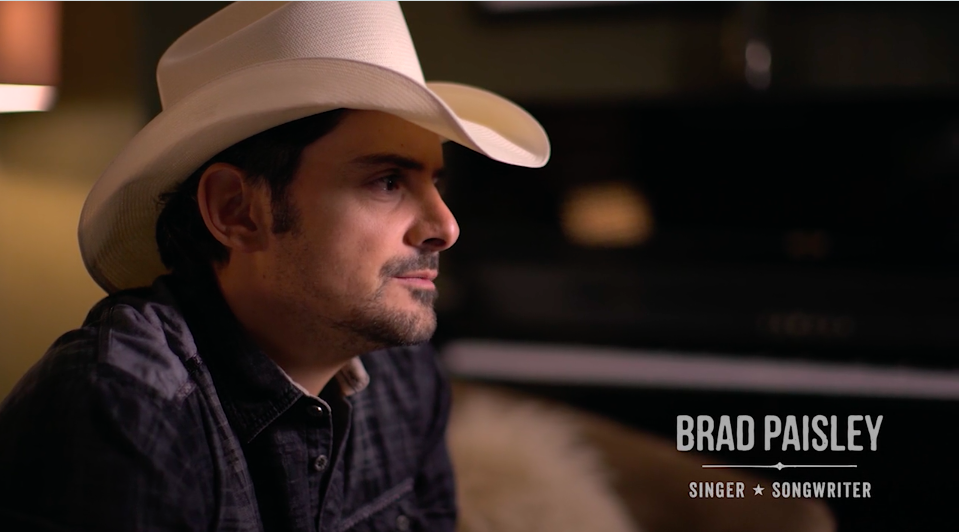 Still from It All Begins With A Song film of Brad Paisley sitting and leaning forward with a white cowboy hat on his head
