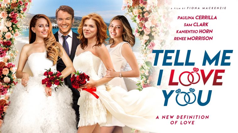 Promotional image for the film "Tell Me I Love You" which sees an image on the left of the four main characters with Kaniehtiio Horn and Paulina Cerrilla in wedding dresses, Sam Clark in a suit, and Renee Morrison in white. On the right side is the actors' names and the title of the film, with the O's being turned into wedding rings.