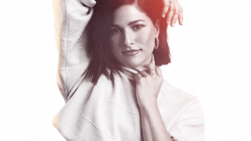Artwork for Rise And Shine which sees Cassadee Pope wearing a cropped long-sleeve white overshirt with her arm over her head.