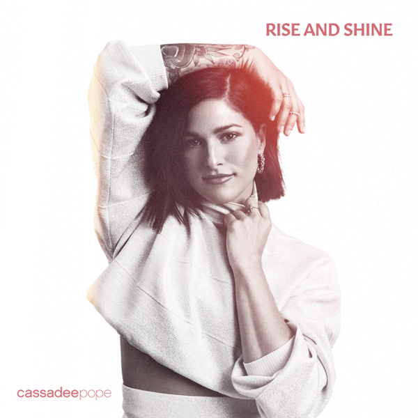 Artwork for Rise And Shine which sees Cassadee Pope wearing a cropped long-sleeve white overshirt with her arm over her head.