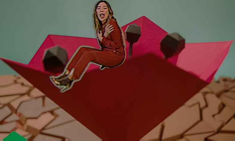 Still from the "Paper Dragon" music video which sees Dami Im in a red jumpsuit displayed as a paper sticker whilst sitting on a paper rose in the desert.