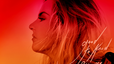 Album artwork for good to know deluxe which is an orangey-red colour with JoJo facing to the left with her hair swept away from her face.