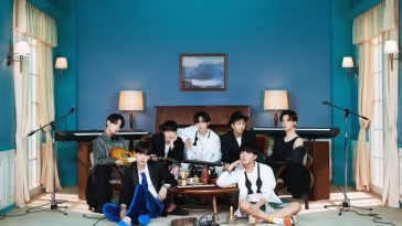 BTS gathered in a room with instruments for the concept cover of their new album BE