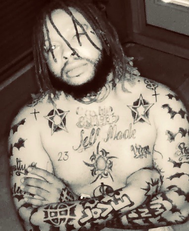 Promotional image for "My Money" which sees a sepia-tone photo of Cashies who is shirtless, bearing his tattoos all over his body. He has shoulder-length dreadlocks and facial hair.