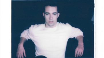 Single cover artwork for "Layover" which sees a square photo of Parker Matthews wearing a white t-shirt and black jeans sitting down with his arms resting behind him, framed by a black border with the artist name at the top and the title at the bottom.