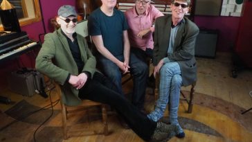 Promotional photo for "Their Mistake" which sees Otherish sitting in a studio. They are four middle to old age men all smiling at the camera.