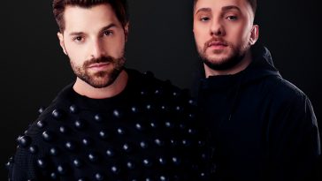 Promotional photo for "Surrender" featuring YOU which sees Alok standing on the left wearing a black jumper with white polka dots, with ÜHÜ on the right wearing a black hoodie.