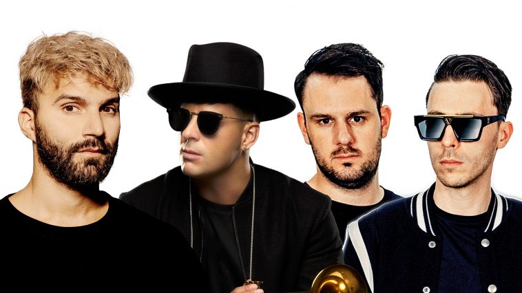 Promotional photo for "Poison" which is an edited photo of all three artists, R3HAB, Timmy Trumpet and W&W all lined up in a row with a white background. They are all wearing black, with R3HAB standing out with his blonde hair and dark beard, Timmy Trumpet is wearing a fedora and sunglasses and he is holding a trumpet, and W&W are wearing varsity jackets.