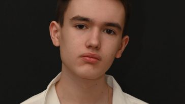 Promotional photo for "Neon" featuring Myah Marie which sees a head shot of Night Acclaim staring into the camera in front of a black background. He is wearing a white shirt and his short black hair is styled.