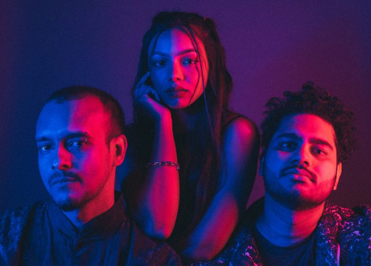 Promotional photo for "Another Avenue" which sees Riya Duggal behind Arrows and Jason D'Souza in a professional photo shoot where a purple filter is used.