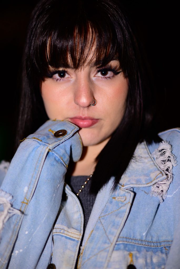 Promotional image for "They Don't Understand Me" featuring Corbin Bronson, which is a headshot of Calliope Wren who has shoulder-length black hair with bangs, and she's wearing a light-blue denim jacket.