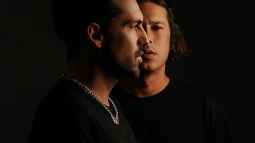 Promotional photo for "Bad For U" in collaboration with Mevil and Enigmix, which sees Chemical Surf posing in a photo studio with one of the brothers facing to the right and the other brother standing behind him and looking at the camera. Both of the DJs are wearing black t-shirts that blend into the background.