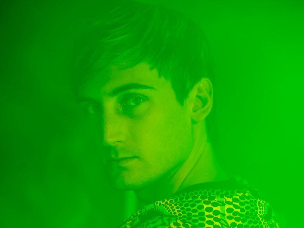 Promotional photo for "Party In My Head" and "Upside" by PLS&TY & Lost Boy and PLS&TY & Ben Samama, respectively, which sees the former in a head shot, looking over one shoulder at the camera. The entire photo is over filtered with a neon green colour.