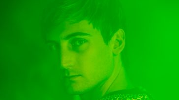 Promotional photo for "Party In My Head" by PLS&TY & Lost Boy which sees the former in a head shot, looking over one shoulder at the camera. The entire photo is over filtered with a neon green colour.