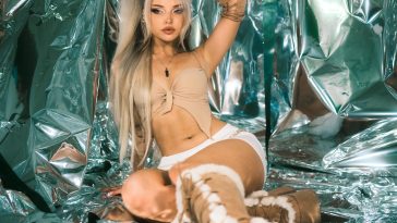 Promotional photo for "I Love You And It's Getting Worse" which sees Larissa Lambert in a metallic mirror room, wearing a nude-coloured bra and white hot pants and knee-high nude fur boots. Her white-grey-dyed hair fall around her beautiful face.