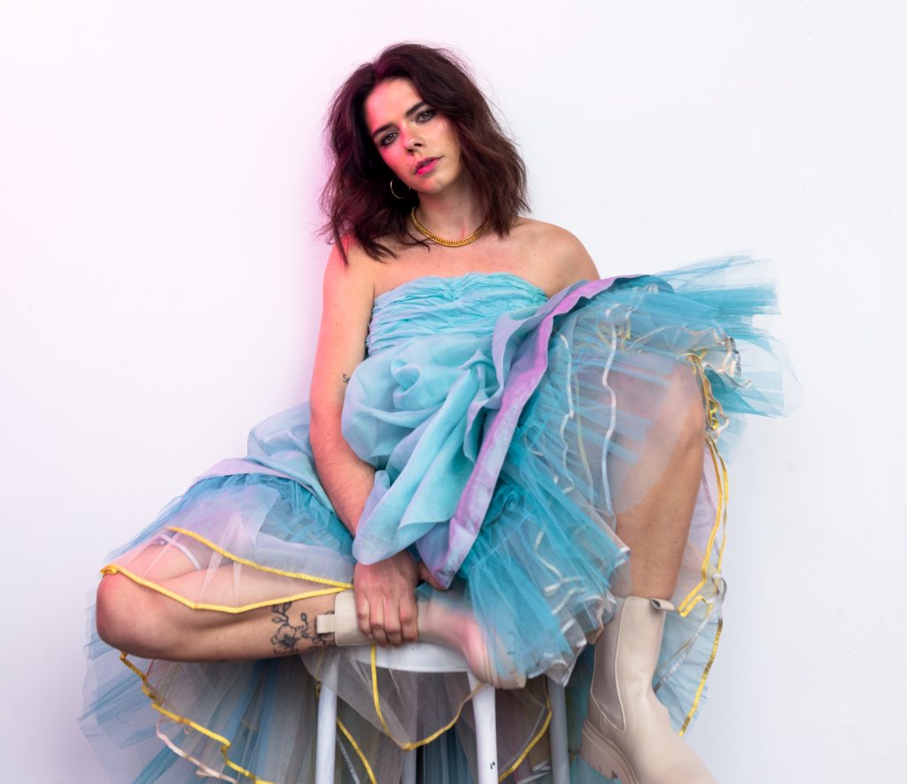 Promotional photo for "Pity Party" that sees Leanne Hoffman on a stool with her legs underneath her, wearing a huge baby blue tutu dress.