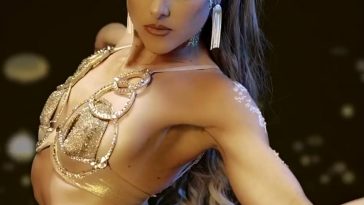 Promotional photo for "Scars" which sees Lyra Star wearing a gold bra with silk straps going down her body, with her back curved backwards with her blonde hair in a long ponytail that falls down her back.