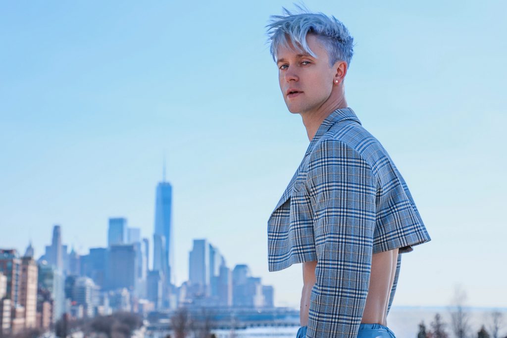 Promotional photo for "Until Tomorrow" which sees Magnus Riise wearing a crop checked blazer, with the New York skyline behind him.