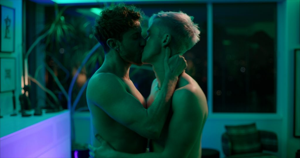 A still from the "Until Tomorrow" music video which sees Magnus Riise and Hernando Umana locking lips in a kiss as they're both shirtless.