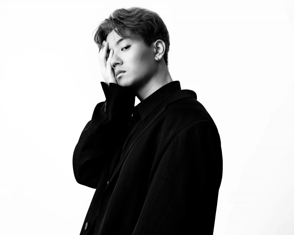 Black and white promotional photo for "Losing My Grip" which sees Milky Day posing side-on with one hand over his face, while looking at the camera. He is wearing black and is clearly in his feels.