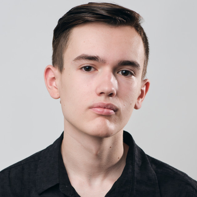 Promotional photo for "Party In The U.S.A." in collaboration with Myah Marie which is a headshot photo of Night Acclaim wearing a black shirt, that matches his short dark hair.