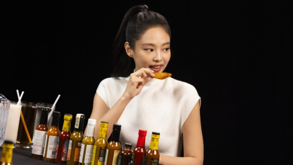 JENNIE from BLACKPINK reacts dramatically while eating spicy wings on Hot Ones interview episode.