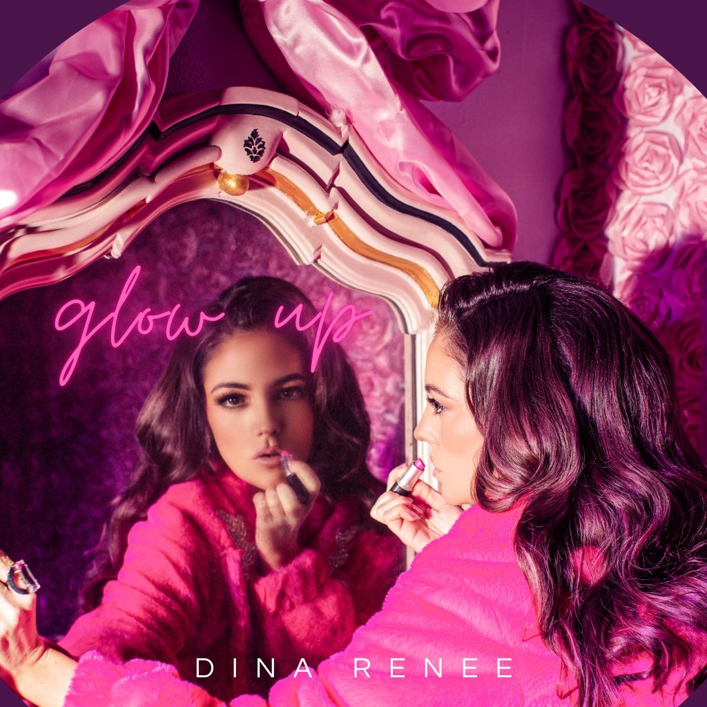 Dina Renée posing in front of a mirror wearing pink, reflecting the confidence and femininity of her new single "Glow Up."

